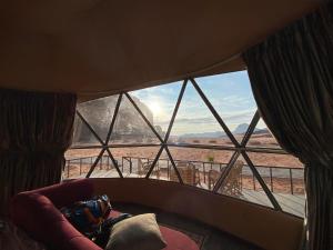 a room with a large window with a view of the desert at WADI Rum STARLIGHT CAMP in Wadi Rum