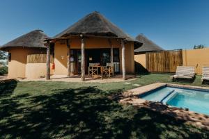 eine Hütte mit einem Pool vor einem Hof in der Unterkunft Mopane Bush Lodge in Linton