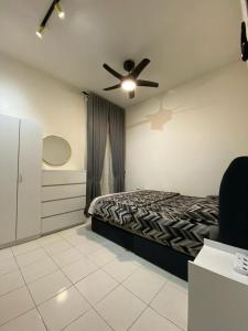 een slaapkamer met een bed en een plafondventilator bij IDAMAN HOMESTAY in Jasin