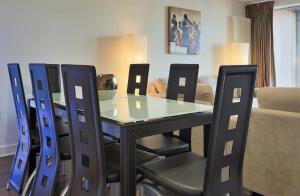 comedor con mesa de cristal y sillas en Large Bright Apartment by Dun Laoghaire Harbour en Dublín