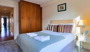 a bedroom with a bed with two towels on it at Large Bright Apartment by Dun Laoghaire Harbour in Dublin