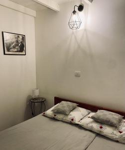 een slaapkamer met een bed en een lampje aan de muur bij Lucky Home - Apartment Art Grožnjan in Grožnjan