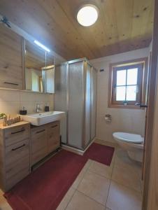 een badkamer met een wastafel, een toilet en een raam bij Berghaus Kessler in Vandans