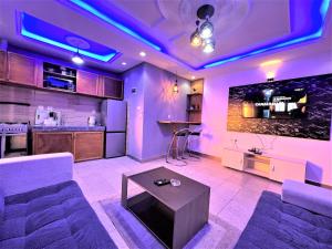 a living room with purple lighting and a table at The Yafé Bastos 17 in Yaoundé