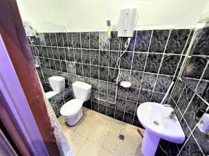 a bathroom with a toilet and a sink at The Yafé Bastos 17 in Yaoundé