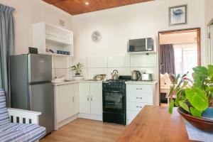 a kitchen with white cabinets and a black refrigerator at VB Escape in Knysna