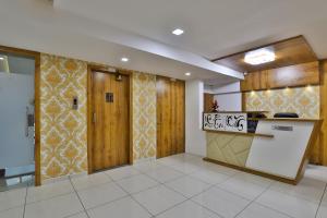a room with wooden walls and a kitchen with a counter at HOTEL SHALIGRAM in Ahmedabad