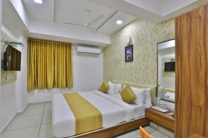 a hotel room with a bed and a mirror at HOTEL SHALIGRAM in Ahmedabad