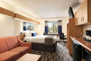 a hotel room with a bed and a kitchen at Microtel Inn & Suites by Wyndham Culpeper in Culpeper