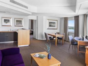 a living room with a couch and a table at Novotel Perth Langley in Perth