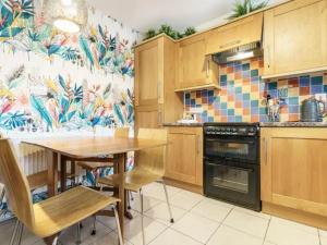 a kitchen with wooden cabinets and a table with chairs at Pass the Keys Lovely Home in Holywood Lots Nearby Seaside in Holywood