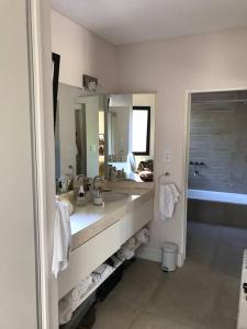 baño con lavabo y espejo grande en Villa Anita, casa con estilo en Luján de Cuyo