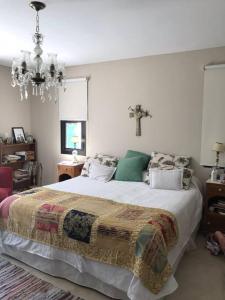 1 dormitorio con 1 cama con una cruz en la pared en Villa Anita, casa con estilo en Luján de Cuyo
