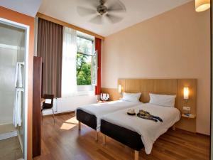 um quarto com uma cama grande e uma janela em ibis Berlin City Süd em Berlim