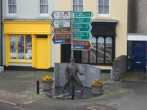 una estatua de un hombre con un montón de carteles callejeros en Holiday in The Heart of Kerry en Castlemaine