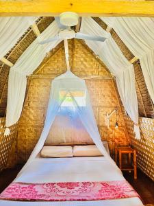 a bed in a room with a ceiling at Boholala hostel in Panglao