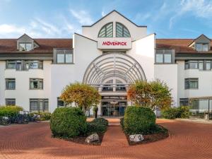 um grande edifício branco com um cartaz em Mövenpick Hotel München-Airport em Hallbergmoos