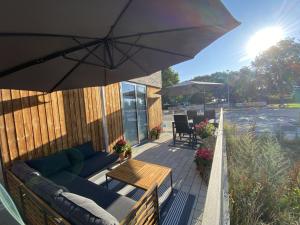 a patio with a couch and a table and an umbrella at ApartmentInCopenhagen Apartment 1460 in Copenhagen