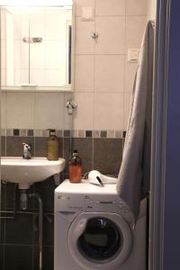 a bathroom with a washing machine and a sink at Residential Hotels Grand Central in Helsinki