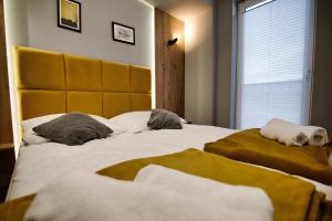 a bedroom with a large bed with two pillows at Apartament No82 Yellow Holiday Home Zator in Zator