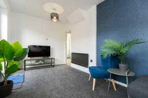 a living room with a tv and a blue wall at Worthy Rest in Stockton-on-Tees