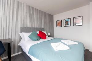 a bedroom with a large bed with colorful pillows at Worthy Rest in Stockton-on-Tees