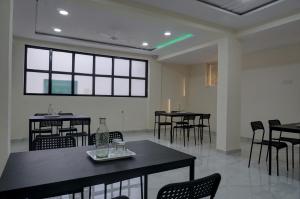 une salle à manger avec des tables et des chaises et une lumière verte dans l'établissement ESTA STAY, à Pune