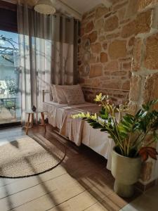 a bedroom with a bed and a stone wall at Studio Eleni - Oasis holiday houses in Kókkinos Pírgos