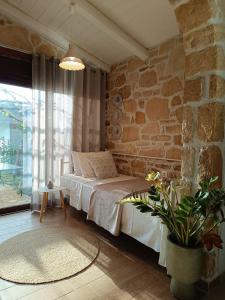 a bedroom with a bed and a stone wall at Studio Eleni - Oasis holiday houses in Kókkinos Pírgos