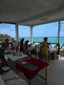 een groep mensen aan tafel op het strand bij Kassandra Beach Hotel in Nungwi