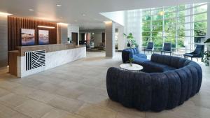 a lobby with a large black couch and chairs at River's Edge Hotel Portland, Tapestry Collection by Hilton in Portland