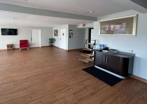 sala de estar con suelo de madera y cocina en Motel 6 Denham Springs, LA, en Denham Springs