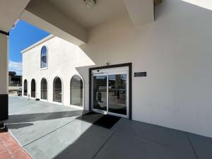 a large white building with a door on the side at Motel 6 Denham Springs, LA in Denham Springs