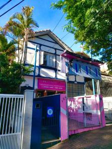 a pink and blue house with a gate at Casa da Vila Hostel Guest House in Sao Paulo