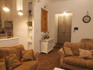 a living room with two couches and a kitchen at Kúria apartman private wellness with garden and pool in Budapest
