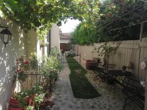 a garden with a table and chairs and a fence at Kúria apartman with private jacuzzi and pool in Budapest