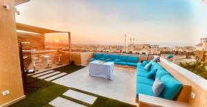 a living room with a blue couch on a balcony at فيلا فندقية بالشيخ زايد in Sheikh Zayed