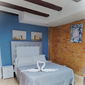バレンシアにあるMurillo Apartmentの白いベッドと青い壁が備わるベッドルーム1室が備わります。