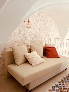 eine Couch mit drei Kissen auf einem Zimmer in der Unterkunft SamSaraHouse Salento in Felline