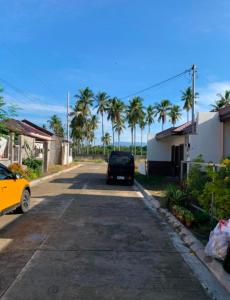 a car parked on a street with palm trees at Radex Place Staycation , 2BR, 6 PAX in Mati