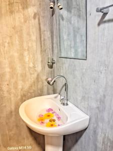 un baño con un lavabo con flores. en Sea sound cabana & Restaurant, en Tangalle