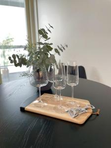 a wooden tray with four wine glasses on a table at Viihtyisä kaksio Santalahdessa in Tampere