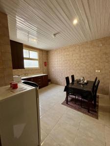 eine Küche mit einem Tisch und Stühlen im Zimmer in der Unterkunft راحة للأجنحة الفندقية Comfort hotel suites in Ha'il