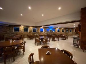 um restaurante com mesas e cadeiras e uma parede de tijolos em Búzios Beach Resort RJ em Búzios
