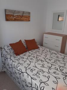 um quarto com uma cama com um edredão preto e branco em PAAL PLAYA Solo Familias em Playa de Gandia