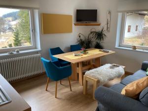 een woonkamer met een tafel en blauwe stoelen bij Haus Werner in Ramsau am Dachstein