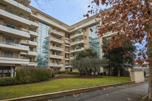 an apartment building with a park in front of it at Nuvola Apartment Fiumicino Easy Self check-in in Fiumicino