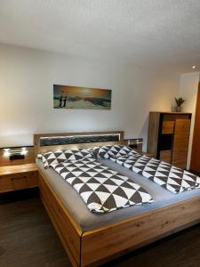ein Schlafzimmer mit einem großen Bett mit einem Bild an der Wand in der Unterkunft Haus Brugger Richard in Zell am Ziller