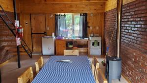 a kitchen with a table and a brick wall at La Estrella complejo del lago in Lago Meliquina