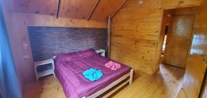 - une petite chambre avec un lit violet dans une cabine dans l'établissement La Estrella complejo del lago, à Villa Meliquina